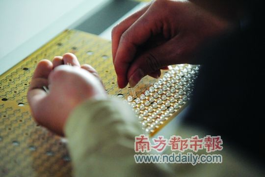 工人忙著安裝用于燈具發(fā)光的LED燈珠，這類工作處于LED燈具生產(chǎn)的最下游。資料圖